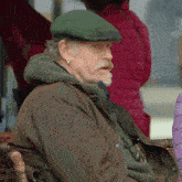 a man with a green hat and a brown jacket
