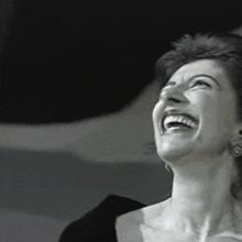 a woman is laughing with her eyes closed