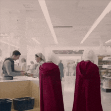 a woman in a red cape stands next to another woman