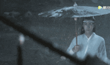 a man holding an umbrella in the rain with chinese characters on the bottom