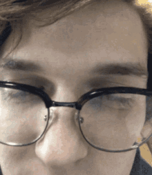 a close up of a person 's face with glasses