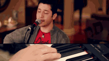a man singing into a microphone and playing a keyboard
