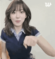 a woman in a blue shirt is making a fist gesture .