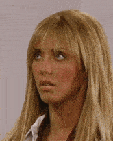 a woman with blonde hair and blue eyes looks at the camera