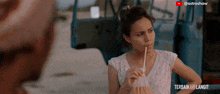 a video of a woman drinking through a straw has astroshaw written above her