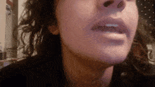 a close up of a woman 's face shows her mouth open
