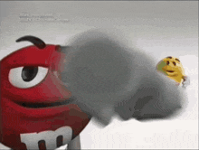 a red m & m with a yellow m & m behind him