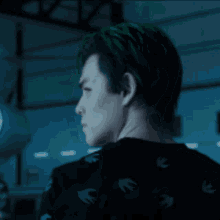 a man with green hair is wearing a black shirt with a pattern of birds on it