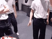 a man in a white shirt is standing next to a cake with berries on it