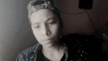 a young boy wearing a hat and a blue shirt looks at the camera