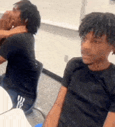 a man with dreadlocks is sitting at a table in front of a mirror .