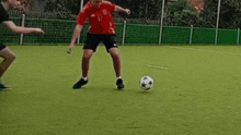 two men are playing soccer on a field and one of them is laying on the grass