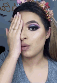 a woman wearing a flower crown covering her face
