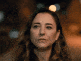 a close up of a woman 's face with a blurry background of lights