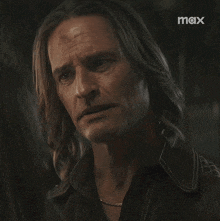 a close up of a man 's face with a max logo in the background