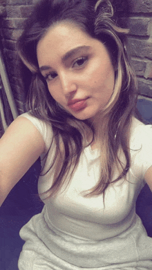 a woman taking a selfie with a white shirt on