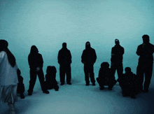 a group of people standing in a circle with a woman standing in the middle