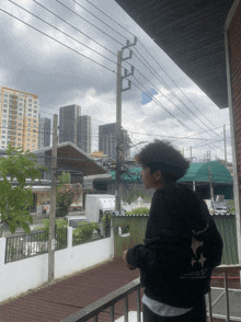 a person standing on a balcony with a sweatshirt that says ' i love you ' on the sleeve