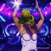 a woman is dancing with a frog on her head and the hashtag tiffanyluv24 is on the bottom