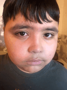 a close up of a young boy 's face with a serious look on his face