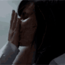 a close up of a woman 's face in a dark room with a blurry background .