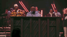 a man is singing into a microphone while another man plays a keyboard