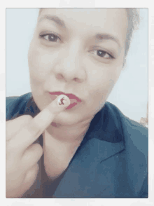 a woman with red lipstick is holding her finger to her lip