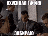 a man in a suit and tie is sitting at a desk with a foreign language caption above him