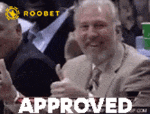 a man in a suit and tie is giving a thumbs up and the word approved is on the bottom