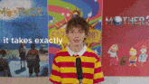 a young man stands in front of three posters one of which says mother