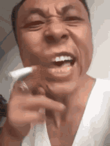 a close up of a man smoking a cigarette with his mouth open