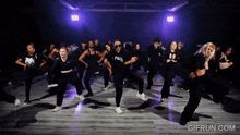 a group of people are dancing in a dark room and one of them is wearing a shirt that says peace