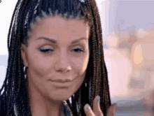 a close up of a woman 's face with braids .