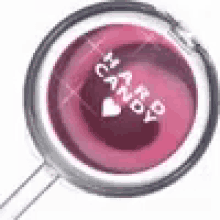 a close up of a pink candy with a heart on it in a magnifying glass .