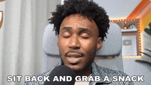 a man sitting in a chair with the words sit back and grab a snack written below him