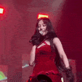 a girl in a red dress is singing into a microphone