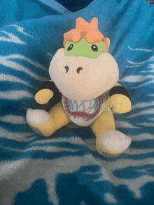 a stuffed animal sitting on a blue blanket