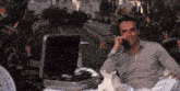 a man is talking on a phone in front of a briefcase