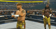 two wrestlers are standing in a ring with a banner that says aew on it