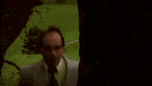 two men in suits and ties are standing next to each other in a park .