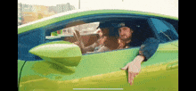 a man is sitting in a green sports car .