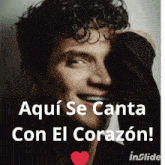 a man with curly hair is smiling with the words aqui se canta con el corazon below him