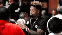 a man is holding a baby in his arms in a crowd