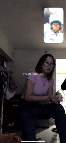 a girl is sitting in front of a phone screen that says trying to reconnect