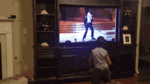 a young boy watches a video of michael jackson on the television