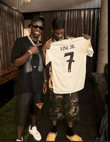 a man holding a jersey that says vini jr