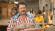 a man with a mustache is wearing an american flag shirt and says never goes away now always in my head .