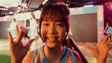 a girl in a blue tank top is smiling in front of a sign that says jkt48 on it