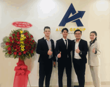 a group of people giving a thumbs up in front of an a group sign