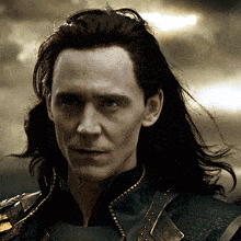a close up of a man 's face with long black hair